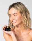 Woman holding A jar of Bella Vida Santa Barbara Brighten Vitamin C Cream with two Beauty Shortlist 2025 and 2024 Award Winner