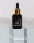 A black bottle with a dropper of Cocomero Watermelon Glow Serum with Hyaluronic Acid, labeled with the brand Bella Vida Santa Barbara luxury skincare, and an award badge for 'Beauty Shortlist Editor's Choice 2024'. The product is described as helping to achieve a glow and radiance for the skin.