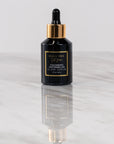 A black bottle with a dropper of Cocomero Watermelon Glow Serum with Hyaluronic Acid, labeled with the brand Bella Vida Santa Barbara luxury skincare, and an award badge for 'Beauty Shortlist Editor's Choice 2024'. The product is described as helping to achieve a glow and radiance for the skin.