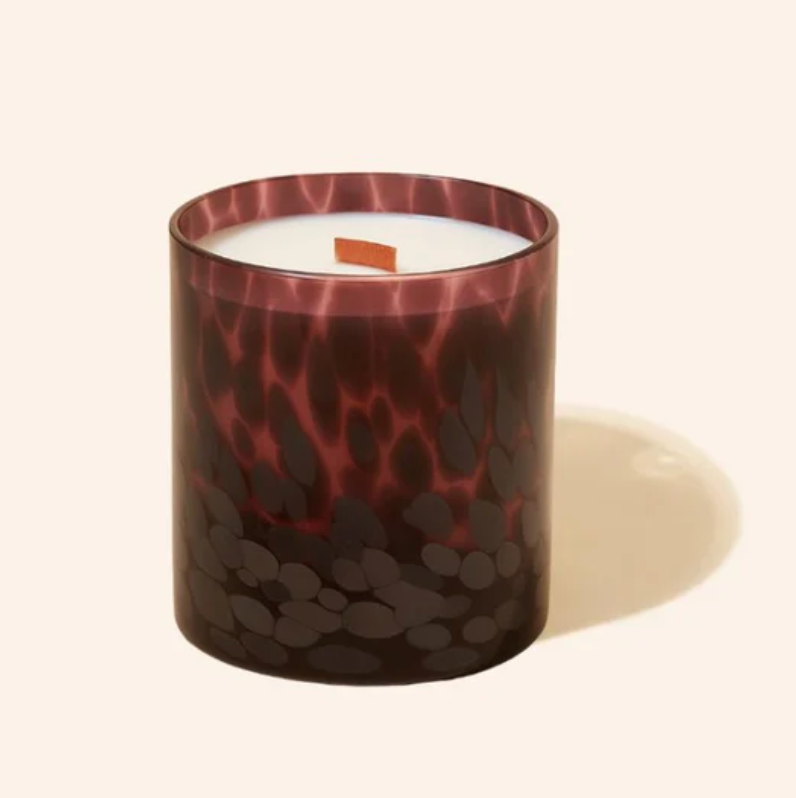 Candle in a decorative glass container with a pattern on a white background