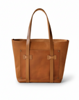 Brown leather tote bag on a beige background